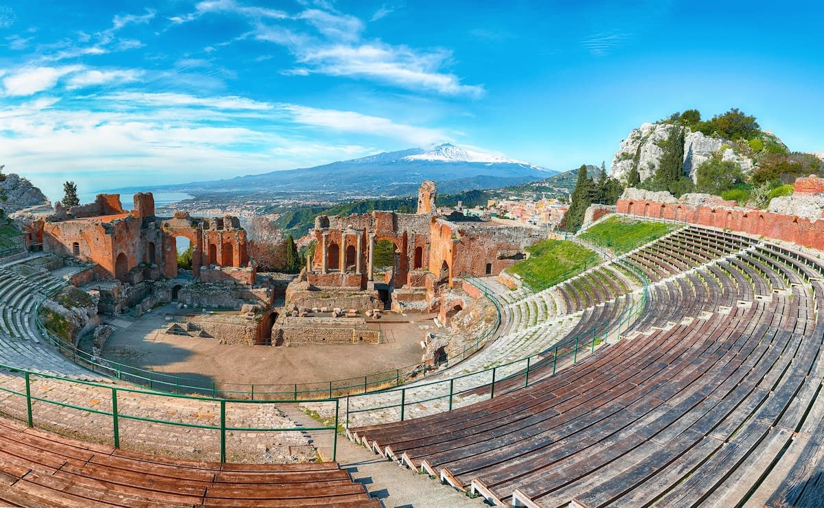 The ancient Greek Theatre of Taormina with Mount Etna in the background during a Sicily tour